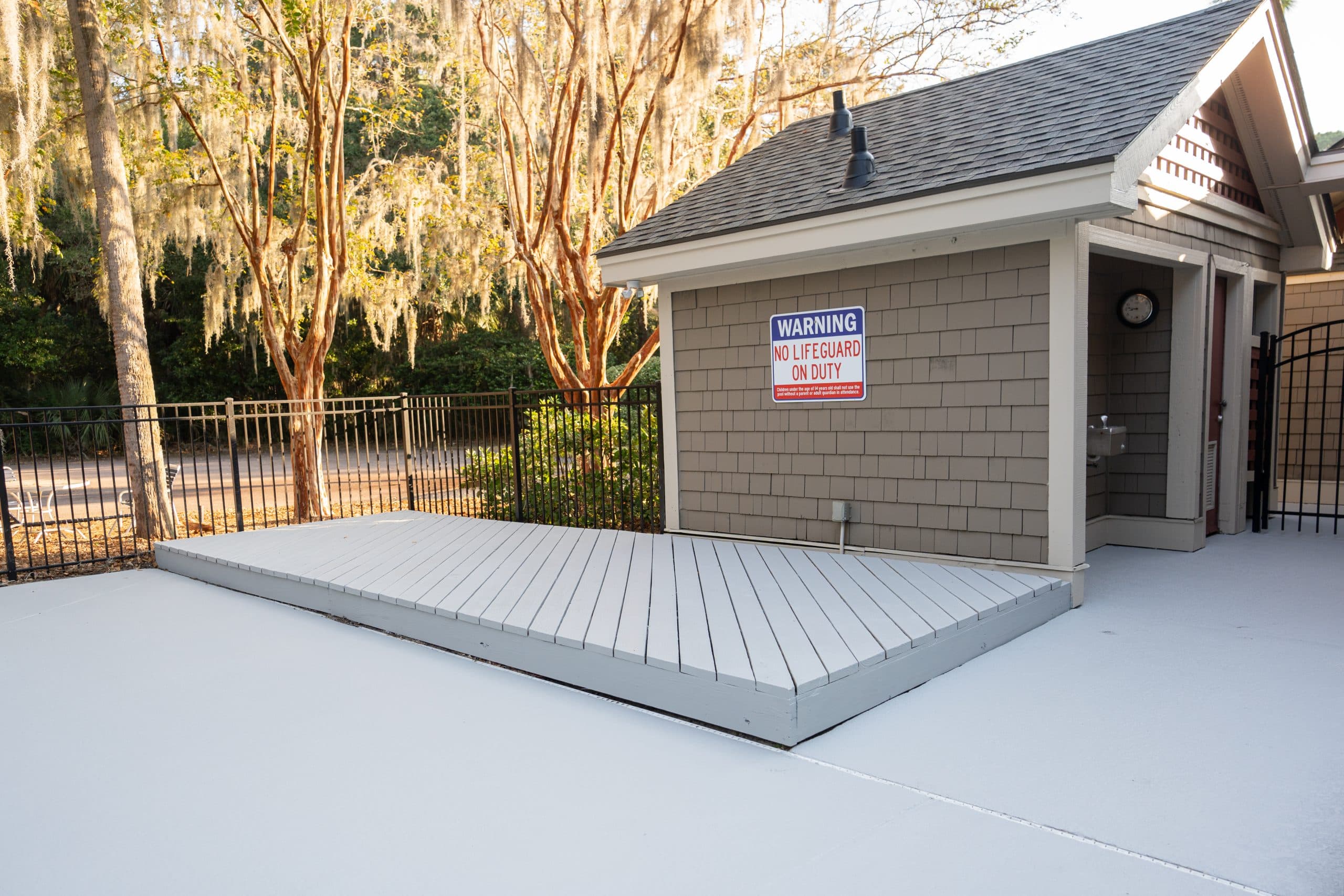 Coated pool deck with transition to wooden ramp